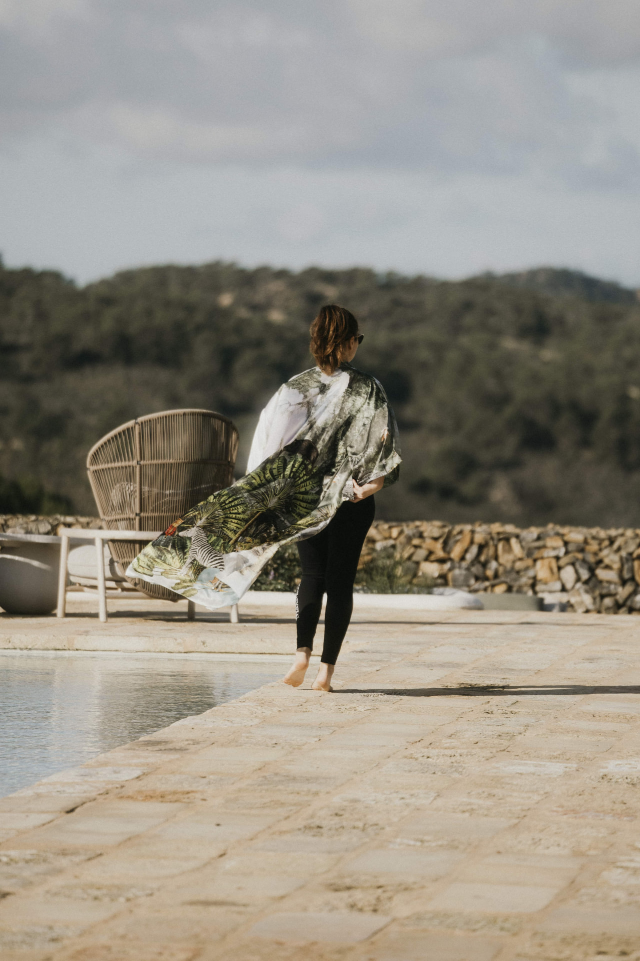 A guest walking by the pool with the hills behind at a Kaer retreat
