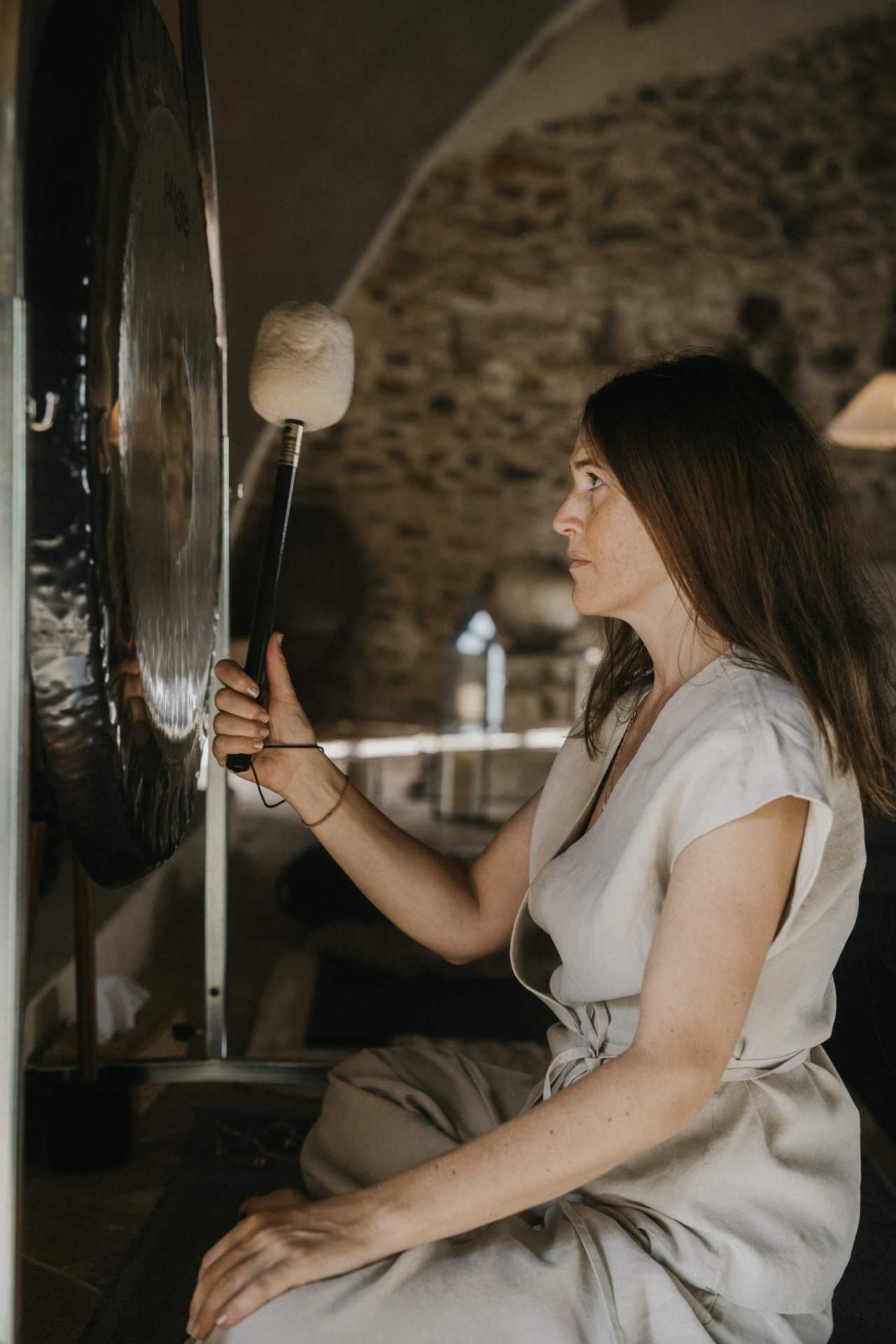 Gong bath in a vaulted stone room at a Kaer retreat
