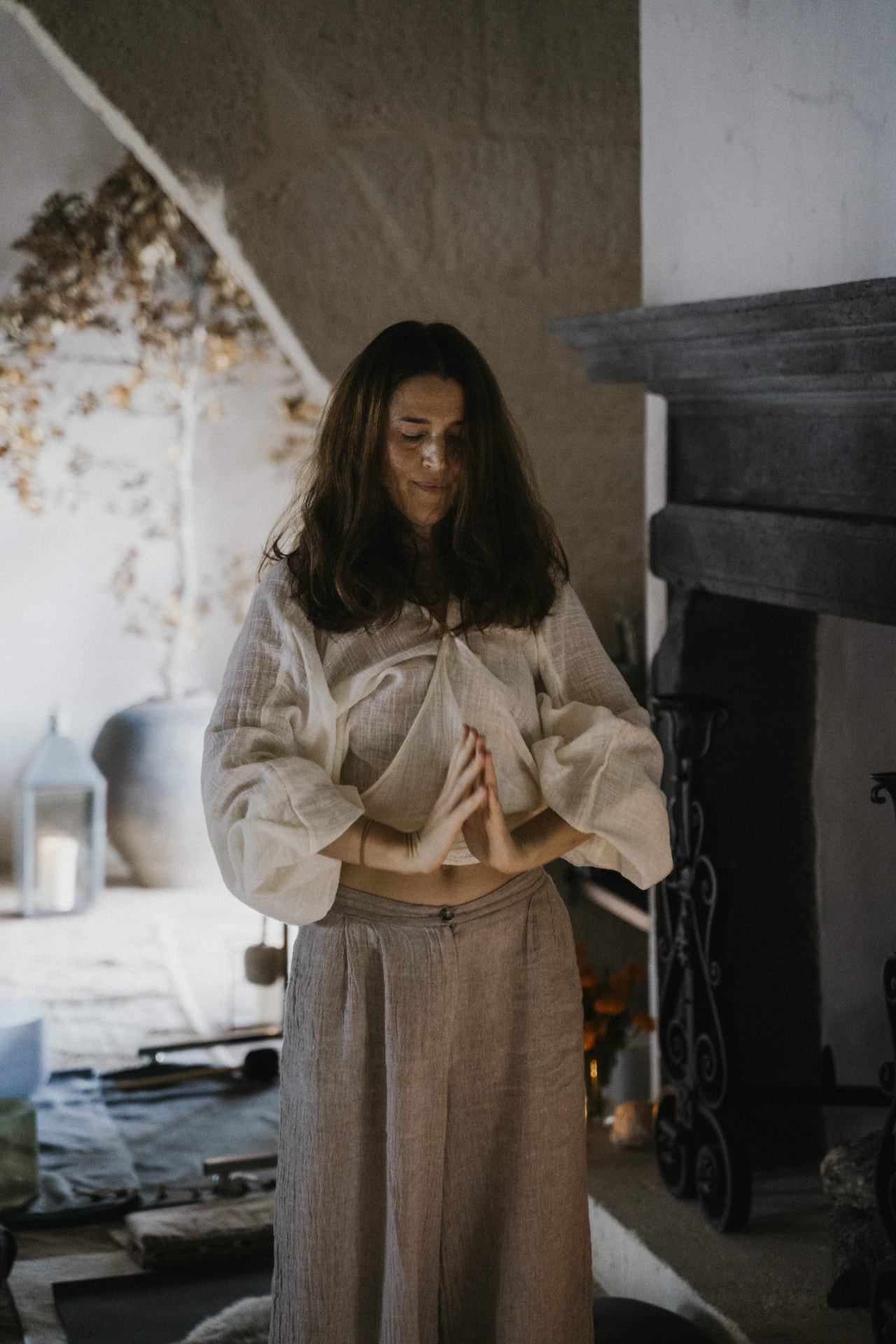 A facilitator standing in stillness by the fireplace at a Kaer retreat