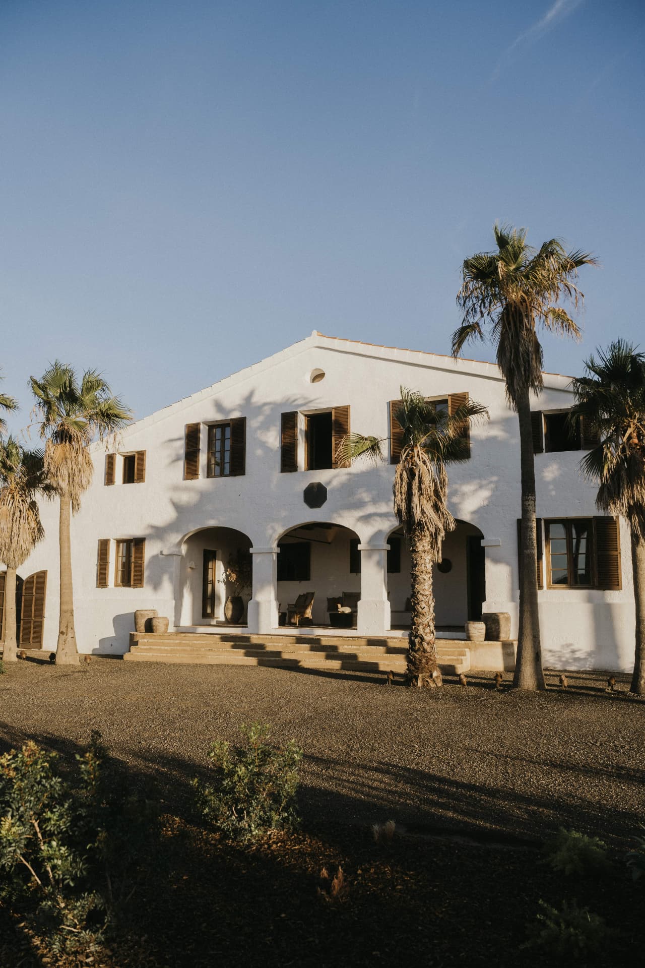 White finca with palm trees at a Kaer retreat